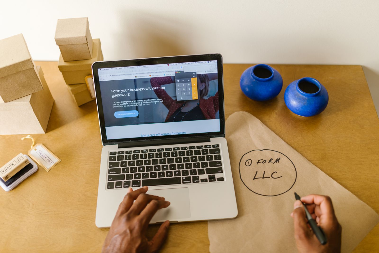 A laptop showing a business formation page next to a hand-drawn note that reads Form LLC
